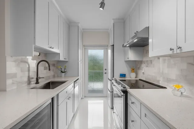 a kitchen with stainless steel appliances a sink a stove and cabinets