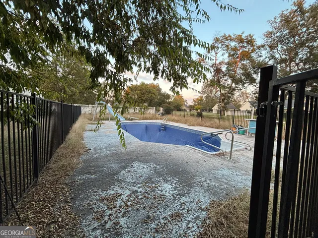 a view of a yard with wooden fence and trees