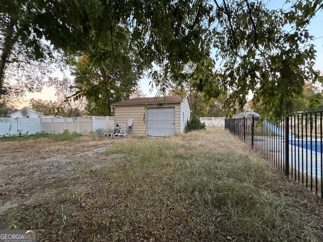 a view of a backyard with large trees and plants
