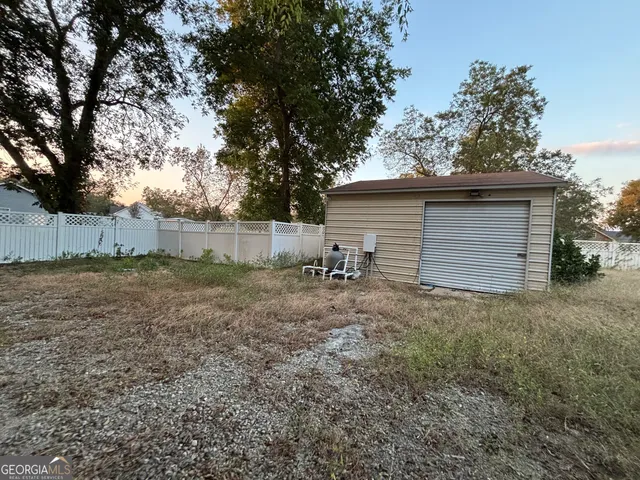 a view of a house with backyard and a tree