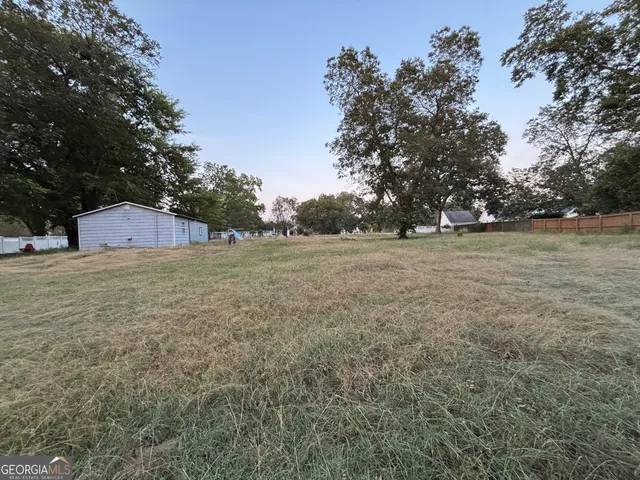 a view of a field with trees in background
