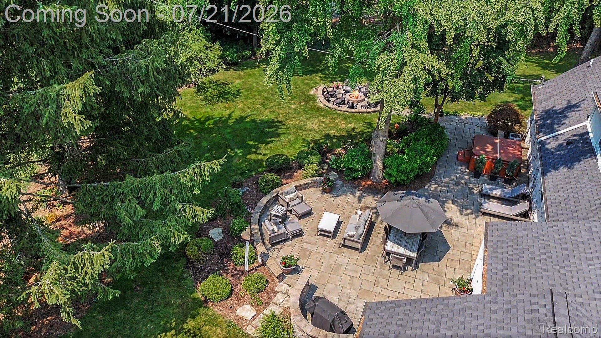 3780 Squirrel Road Bloomfield Hills, MI 48304 - Photo 53 of 59 Expansive backyard featuring a large stone patio, fire pit, and mature trees
