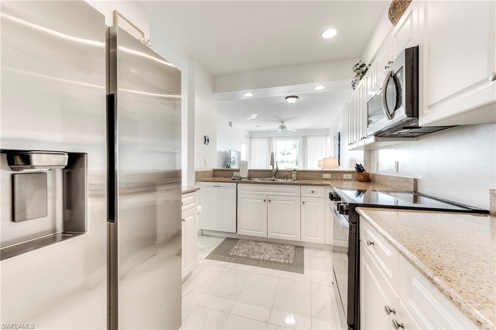 7955 Mahogany Run Lane, Unit 514 Naples, FL 34113 - Photo 11 of 30 a kitchen with a sink stainless steel appliances and cabinets