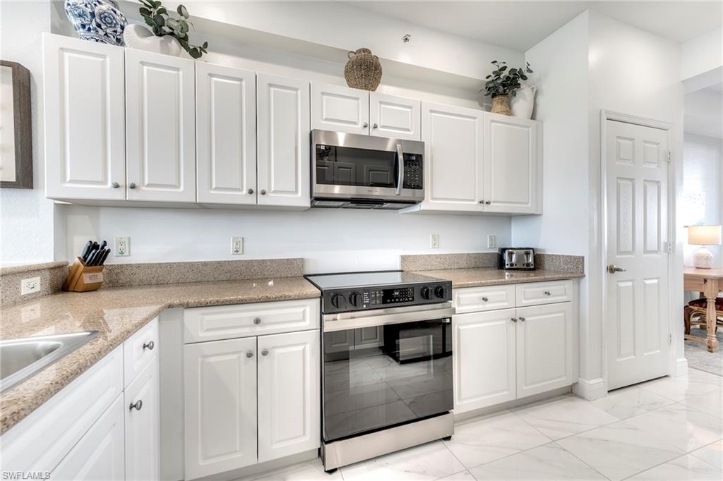 7955 Mahogany Run Lane, Unit 514 Naples, FL 34113 - Photo 12 of 30 a kitchen with stainless steel appliances granite countertop a stove sink and cabinets