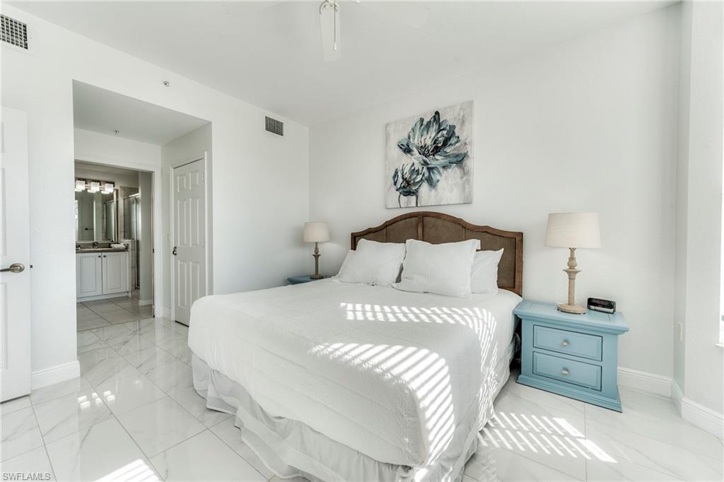 7955 Mahogany Run Lane, Unit 514 Naples, FL 34113 - Photo 21 of 30 a bedroom with a bed and a table