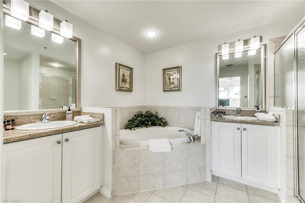 7955 Mahogany Run Lane, Unit 514 Naples, FL 34113 - Photo 23 of 30 a bathroom with a sink vanity tub and a mirror