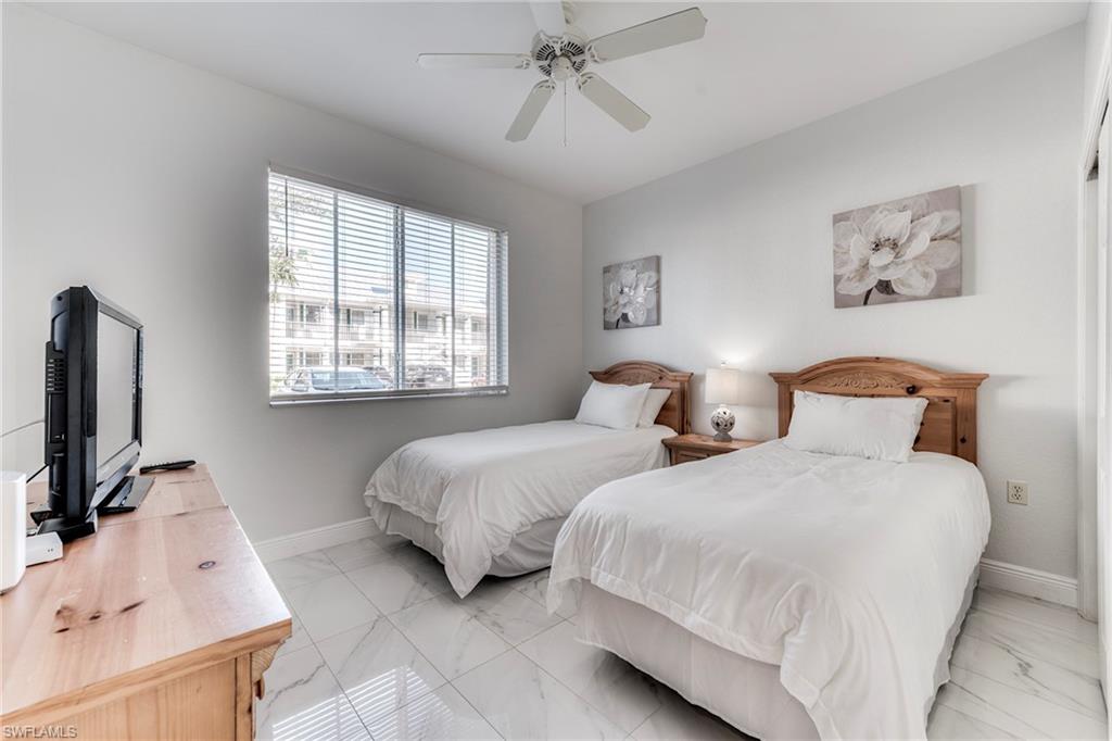 7955 Mahogany Run Lane, Unit 514 Naples, FL 34113 - Photo 26 of 30 a bedroom with two beds and a flat screen tv