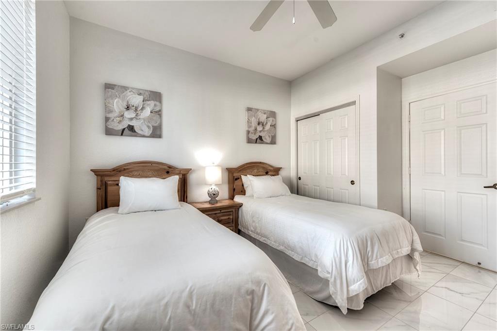 7955 Mahogany Run Lane, Unit 514 Naples, FL 34113 - Photo 27 of 30 a bedroom with two beds and a lamp on dresser