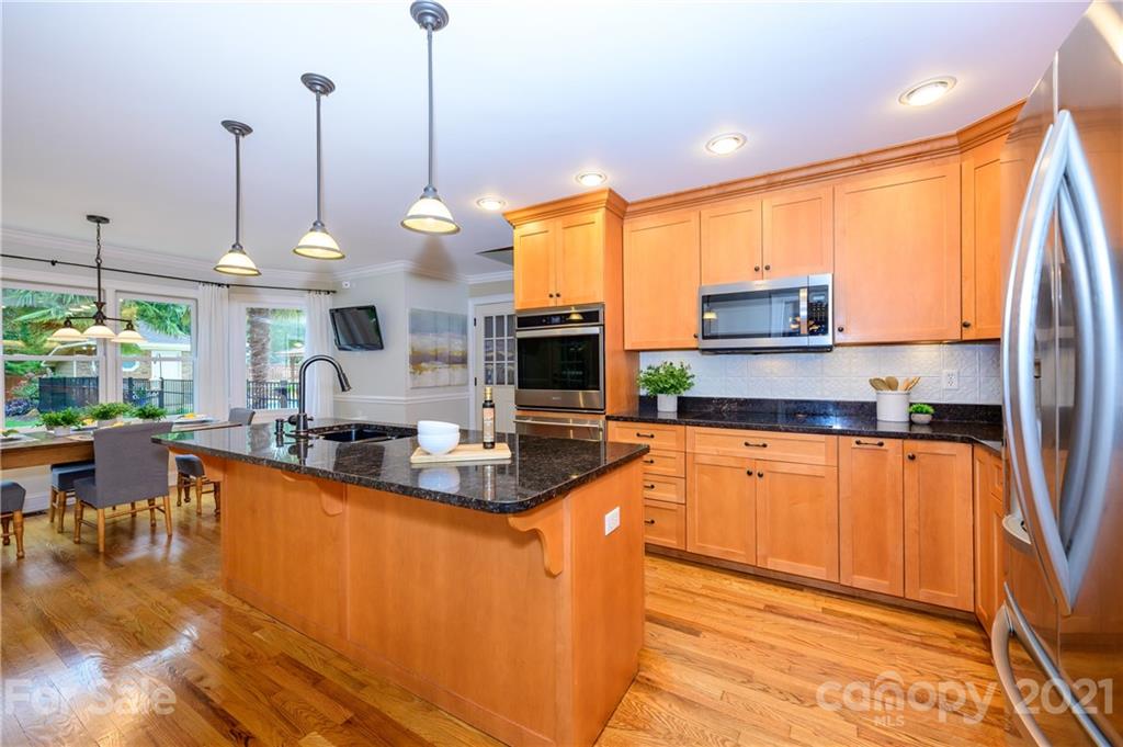 8456 Fairfield Forest Road Denver, NC 28037 - Photo 12 of 38 a kitchen with stainless steel appliances granite countertop a sink a stove and a wooden floors