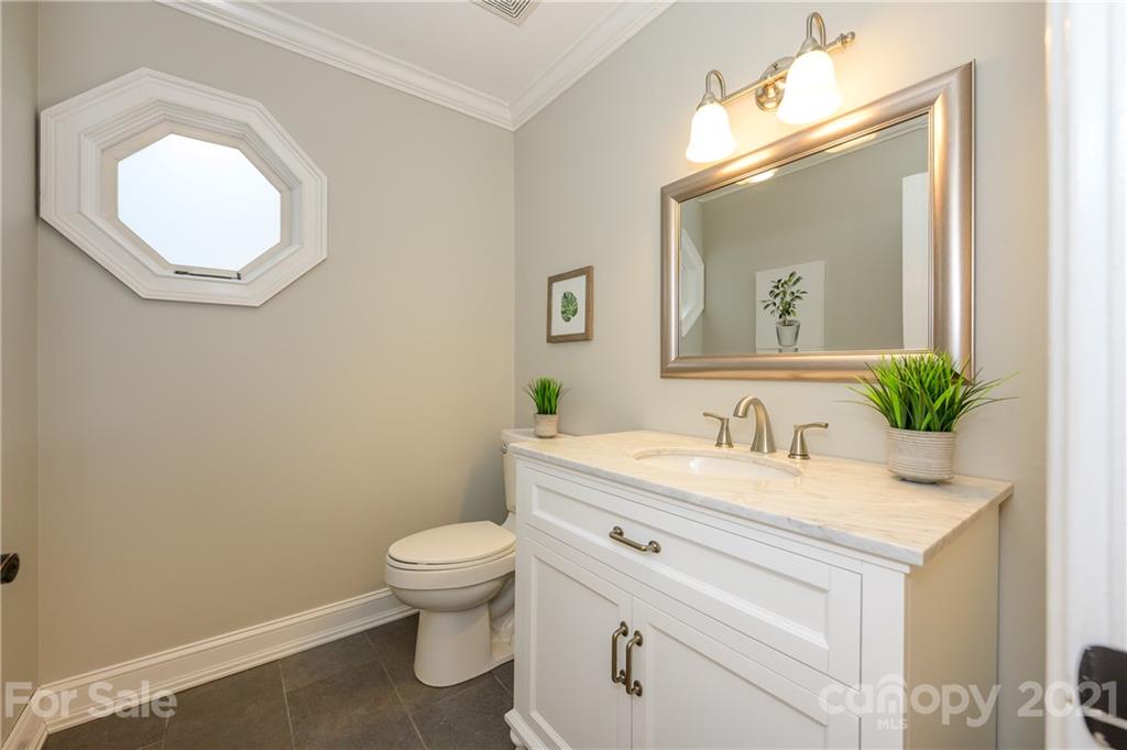 8456 Fairfield Forest Road Denver, NC 28037 - Photo 18 of 38 a bathroom with a granite countertop toilet a sink and a mirror