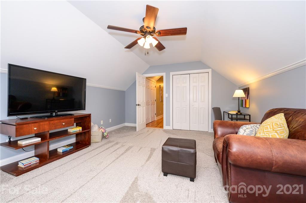 8456 Fairfield Forest Road Denver, NC 28037 - Photo 28 of 38 a living room with furniture and a flat screen tv