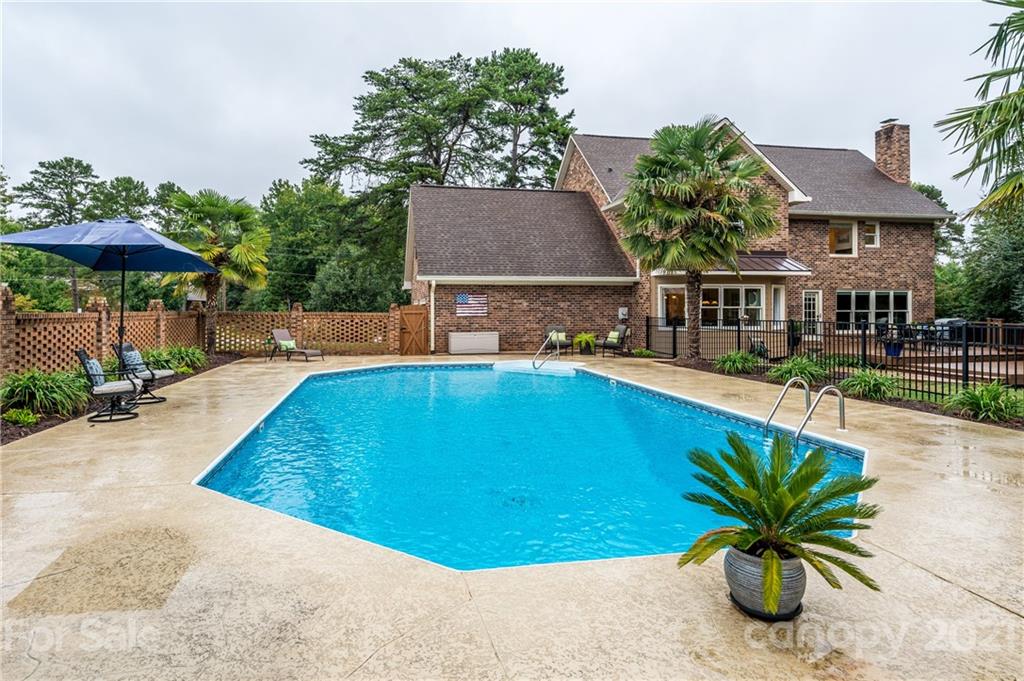 8456 Fairfield Forest Road Denver, NC 28037 - Photo 33 of 38 a view of a swimming pool with a lounge chairs and a table and chairs