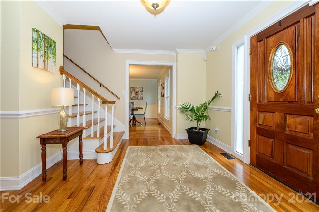 8456 Fairfield Forest Road Denver, NC 28037 - Photo 4 of 38 a view of a hallway with wooden floor and a chandelier