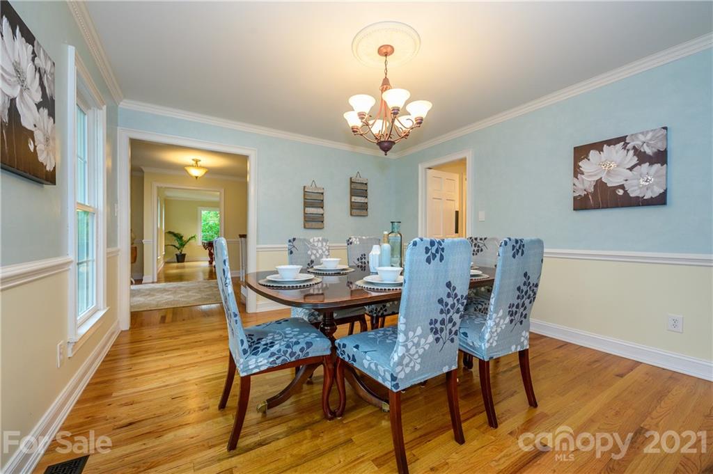 8456 Fairfield Forest Road Denver, NC 28037 - Photo 7 of 38 a view of a dining room with furniture wooden floor and a chandelier