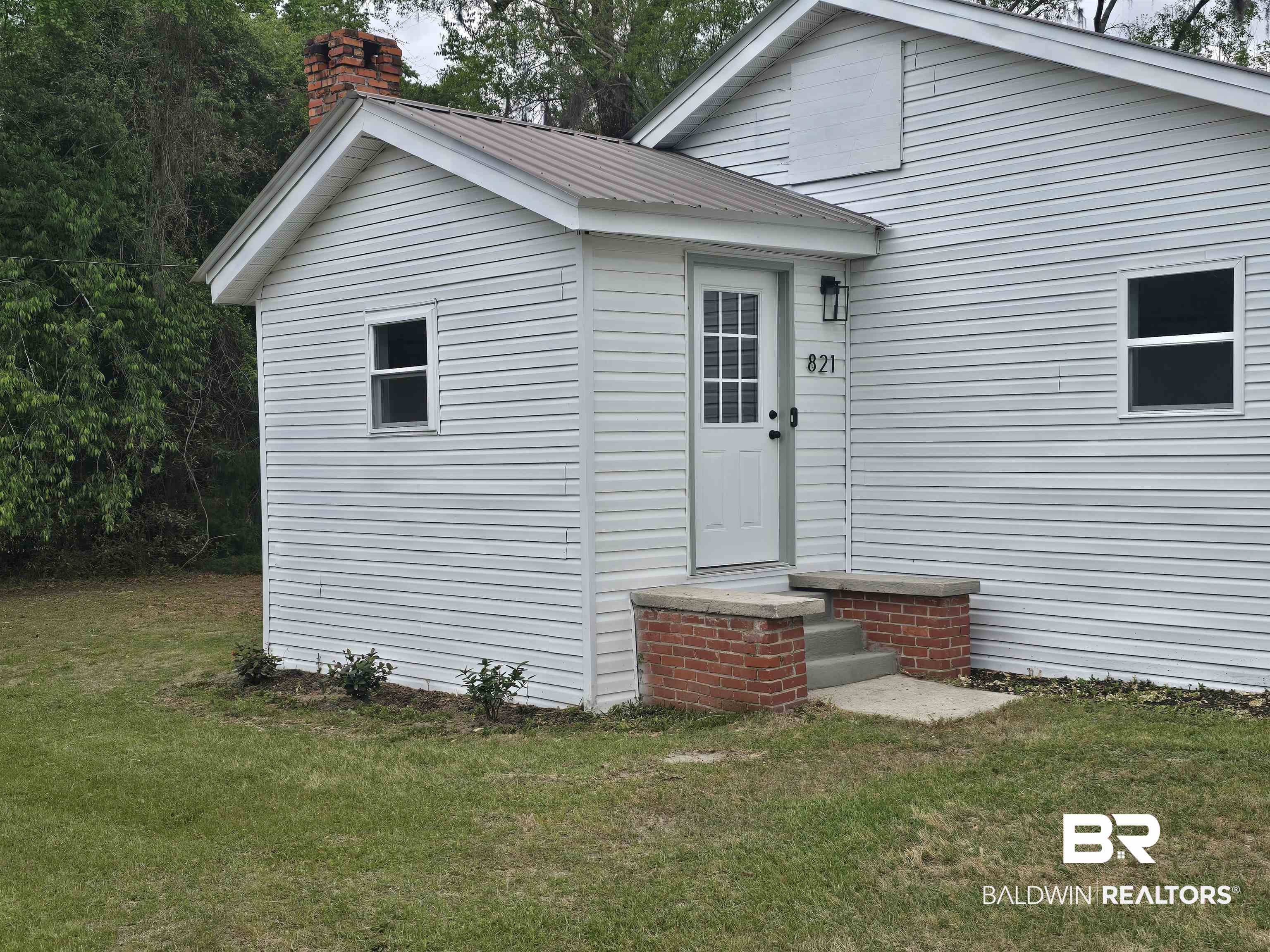 821 Dailey Street Brewton, AL 36426 - Photo 2 of 17 Entrance to property with a yard, a metal roof, and a chimney