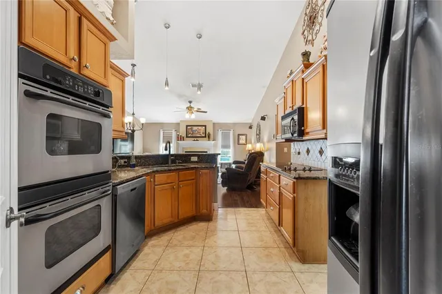 a kitchen with stainless steel appliances granite countertop a sink stove and cabinets