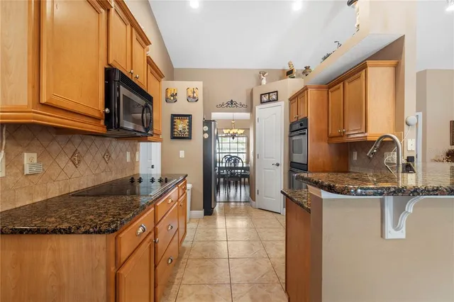 a kitchen with stainless steel appliances granite countertop a sink stove and microwave