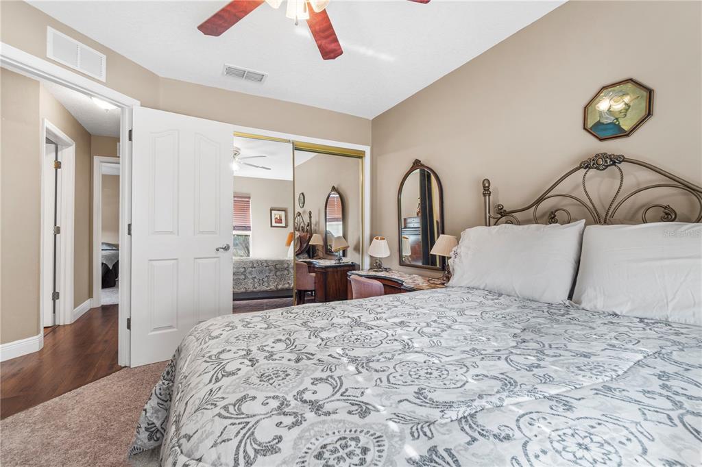 4642 Southwest 100th Lane Ocala, FL 34476 - Photo 27 of 61 a bedroom with a bed and a dresser with mirror