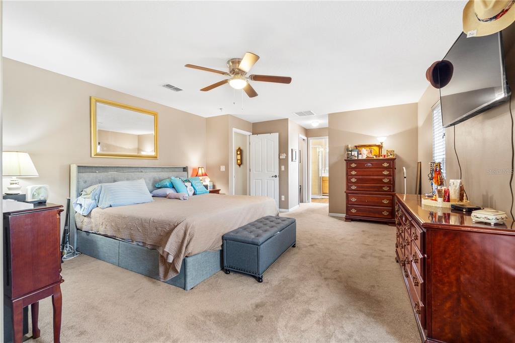 4642 Southwest 100th Lane Ocala, FL 34476 - Photo 33 of 61 a spacious bedroom with a bed and ceiling fan