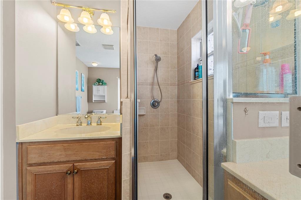 4642 Southwest 100th Lane Ocala, FL 34476 - Photo 36 of 61 a bathroom with a sink vanity granite tub shower and a mirror