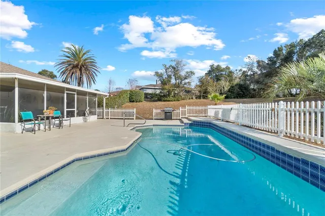 an aerial view of a house with swimming pool and lake view