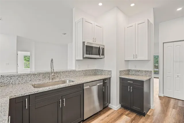 a kitchen with stainless steel appliances granite countertop a stove a sink and a microwave