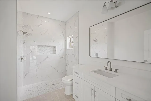 a bathroom with a sink toilet a shower and a mirror