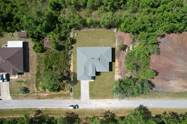 an aerial view of a house with yard and lake view