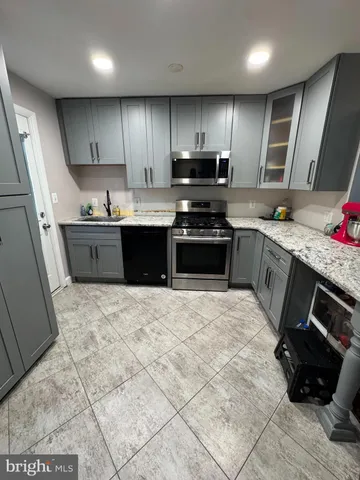 a large kitchen with stainless steel appliances granite countertop a stove granite counter tops a sink a stove a refrigerator and microwave