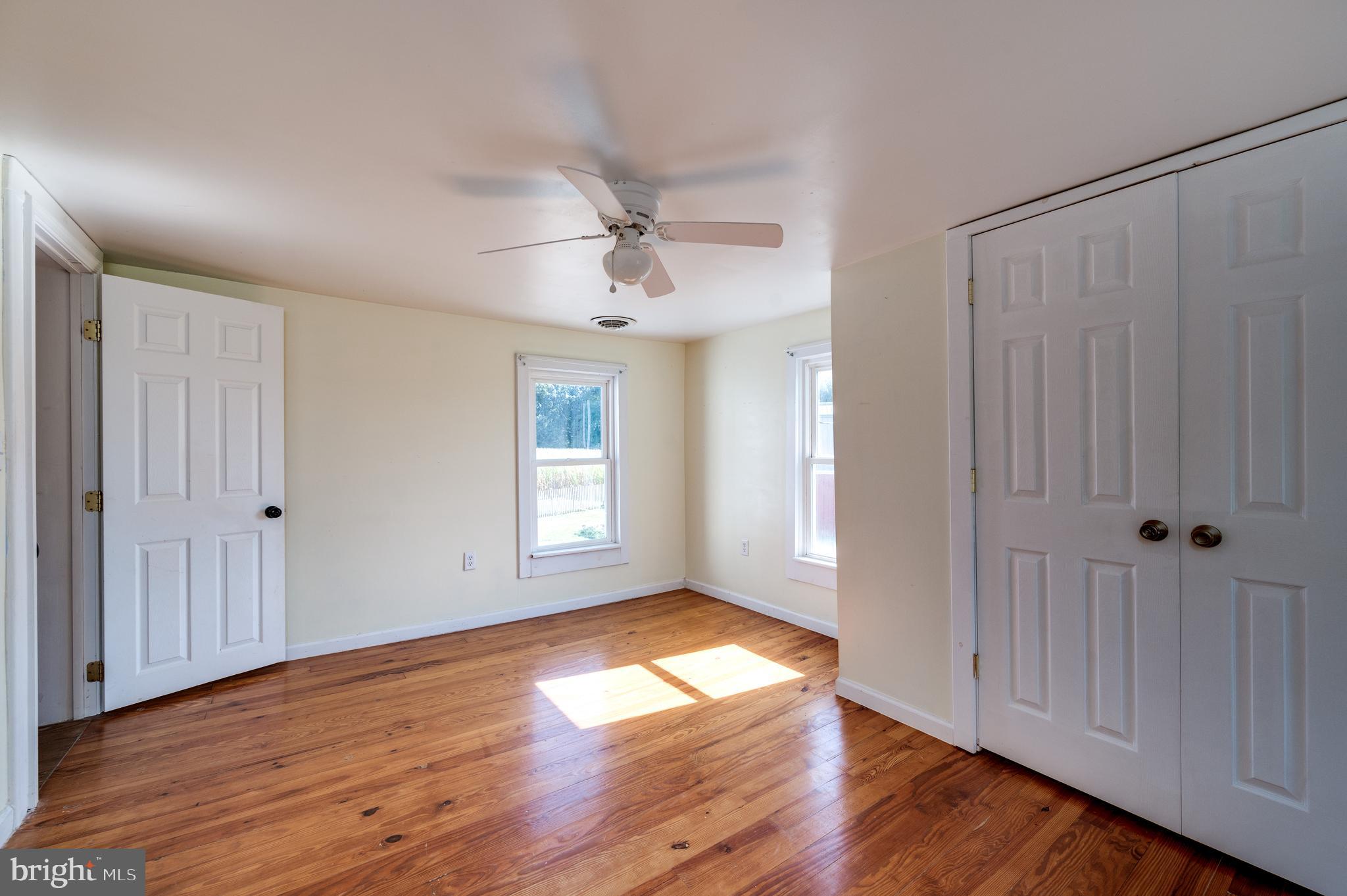4855 Stonesifer Road Taneytown, MD 21787 - Photo 24 of 65 an empty room with wooden floor and windows with curtains