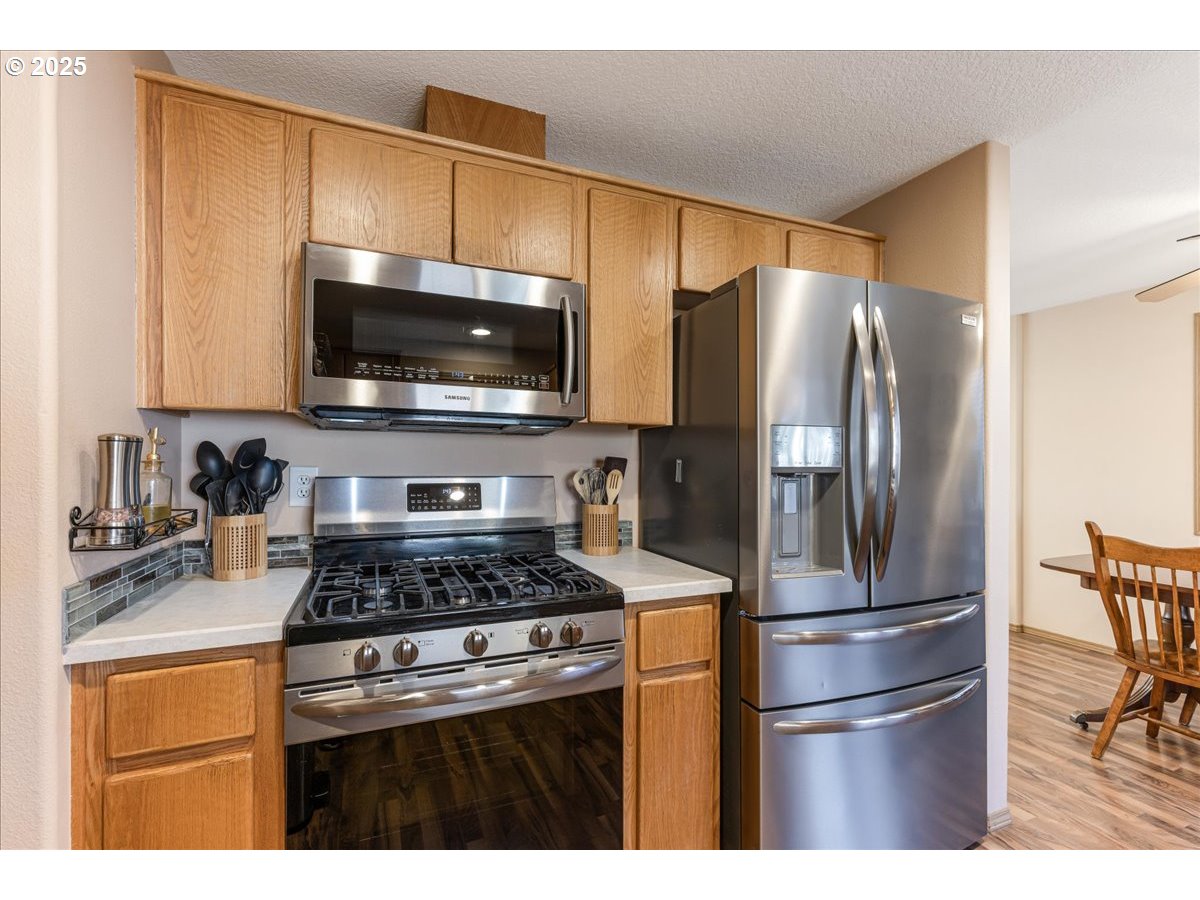 3977 Southeast Salquist Road Gresham, OR 97080 - Photo 29 of 33 a kitchen with stainless steel appliances granite countertop a refrigerator stove and microwave