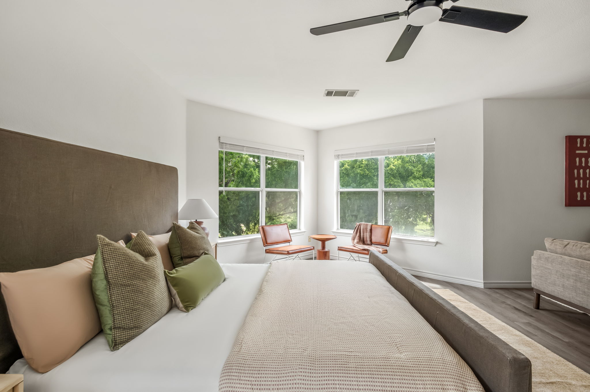 1408 Water Spaniel Way Round Rock, TX 78664 - Photo 26 of 37 A tranquil primary bedroom with ample light, featuring a modern ceiling fan and serene tree-lined views.