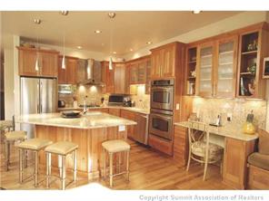 504 Ridge Street, Unit 504 Breckenridge, CO 80424 - Photo 4 of 17 a kitchen with stainless steel appliances kitchen island granite countertop a table and chairs