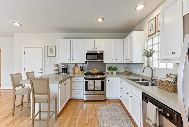 a kitchen with granite countertop white cabinets and white appliances