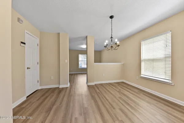 a view of a room with window wooden floor and chandelier