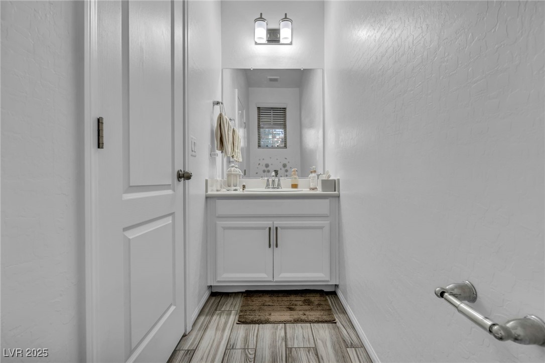 854 Earth Luster Road Las Vegas, NV 89178 - Photo 30 of 65 Bathroom with wood finish floors, vanity, and baseboards