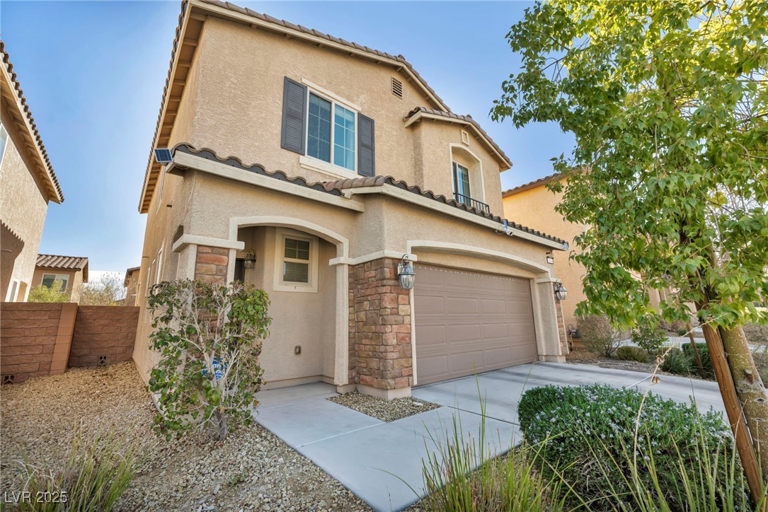 854 Earth Luster Road Las Vegas, NV 89178 - Photo 3 of 65 Mediterranean / spanish home featuring driveway, stone siding, a garage, and stucco siding