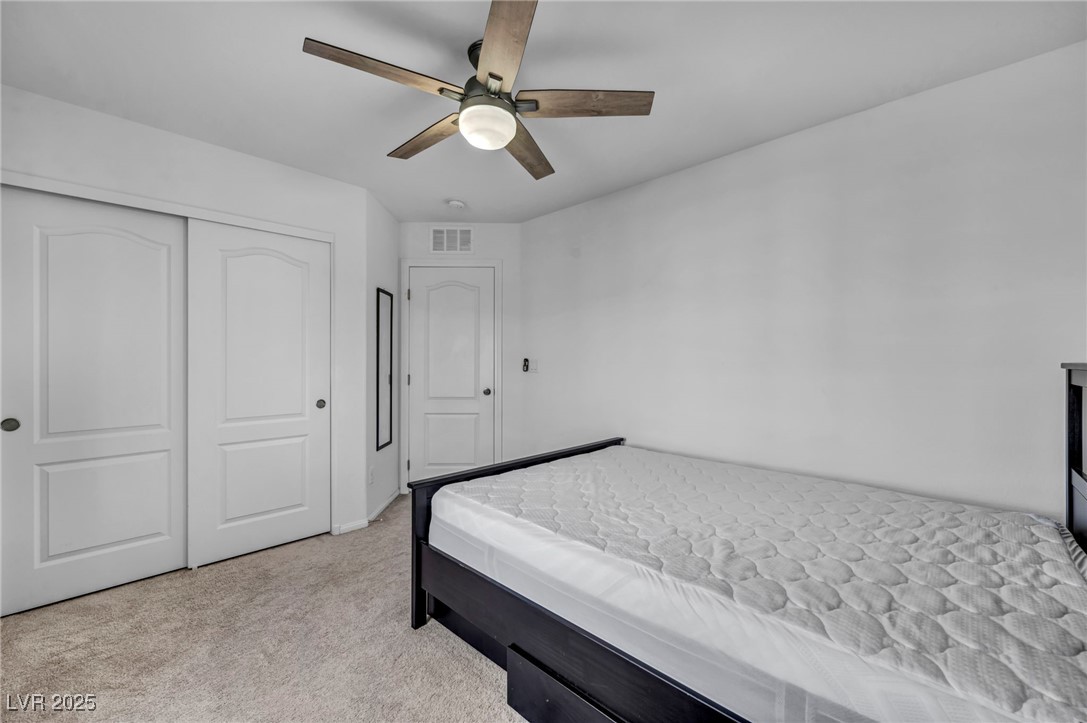 854 Earth Luster Road Las Vegas, NV 89178 - Photo 35 of 65 Bedroom featuring a ceiling fan, light colored carpet, a closet, and visible vents