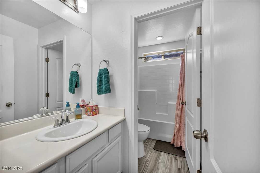 854 Earth Luster Road Las Vegas, NV 89178 - Photo 37 of 65 Full bathroom with vanity, wood finished floors, shower / bath combination with curtain, and toilet