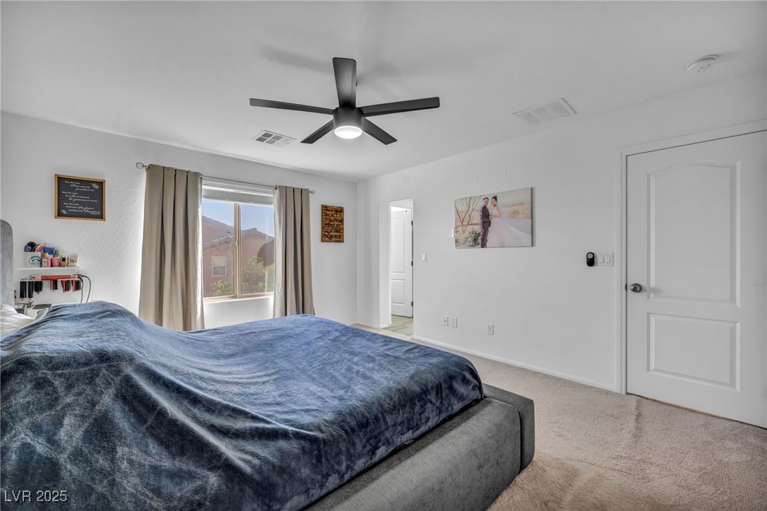 854 Earth Luster Road Las Vegas, NV 89178 - Photo 43 of 65 Bedroom with light carpet, a ceiling fan, visible vents, and baseboards