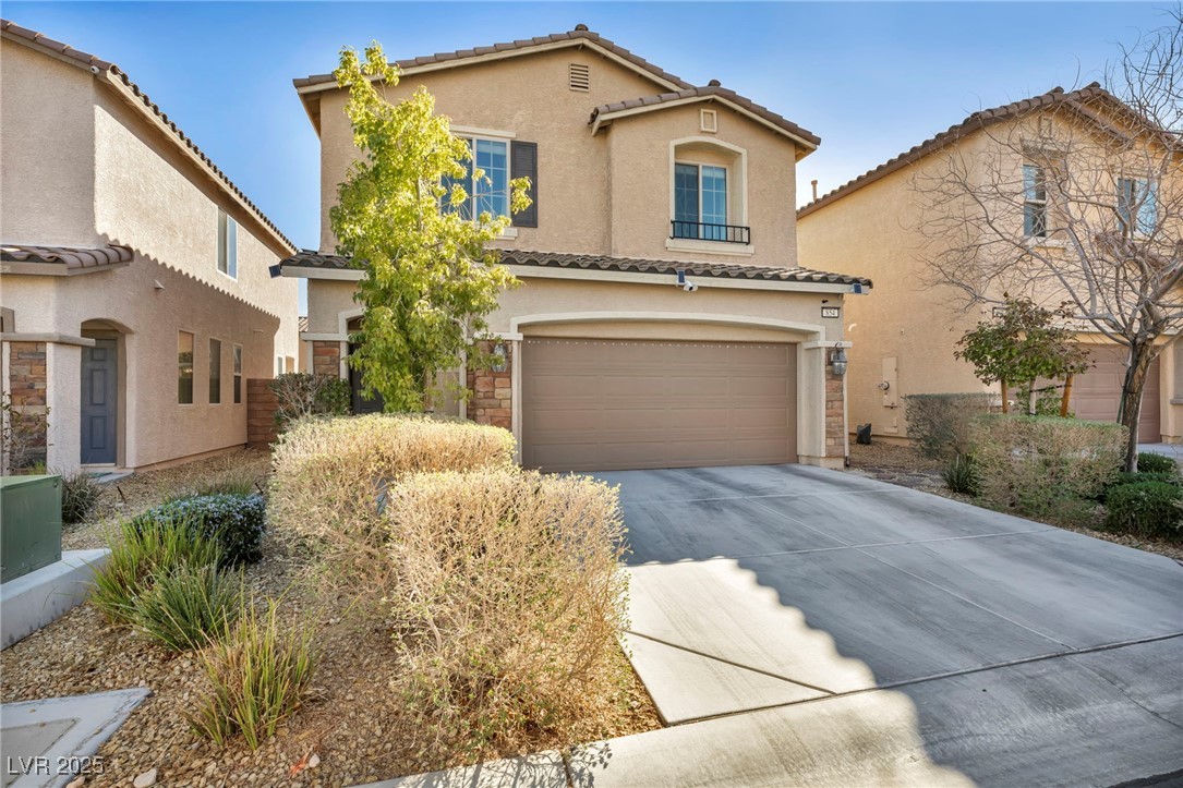 854 Earth Luster Road Las Vegas, NV 89178 - Photo 5 of 65 Mediterranean / spanish-style home featuring a garage, concrete driveway, a tiled roof, and stucco siding