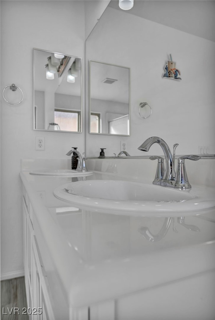 854 Earth Luster Road Las Vegas, NV 89178 - Photo 55 of 65 Bathroom with double vanity, wood finished floors, a sink, and visible vents