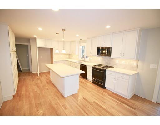 43 Bellflower Road Billerica, MA 01821 - Photo 3 of 13 a large white kitchen with a stove top oven a sink dishwasher and a refrigerator with wooden floor