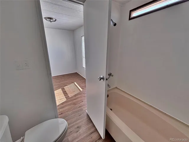 a bathroom with a tub and toilet