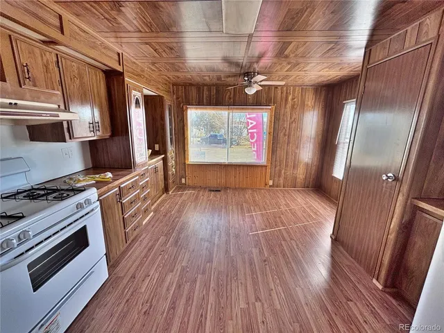 a view of a kitchen with wooden floors and appliances