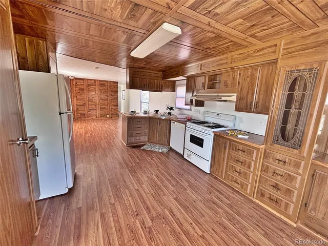a kitchen with stainless steel appliances wooden floors and wooden cabinets