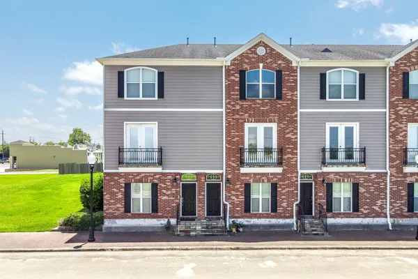 a front view of a house with yard and green space