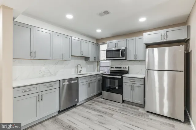 a kitchen with cabinets stainless steel appliances and a window