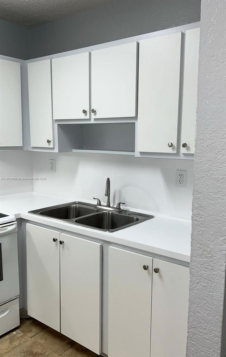 575 West 69th Street, Unit 208 Hialeah, FL 33014 - Photo 2 of 10 a kitchen with white cabinets and white appliances