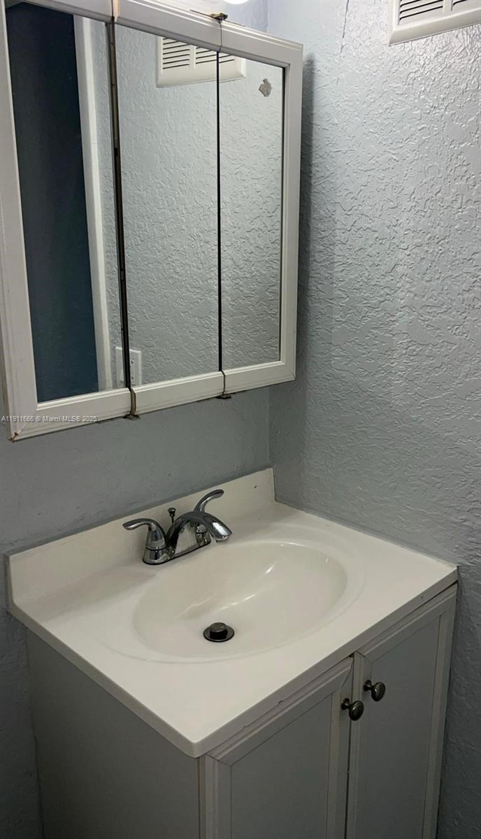 575 West 69th Street, Unit 208 Hialeah, FL 33014 - Photo 7 of 10 a bathroom with a sink and a mirror